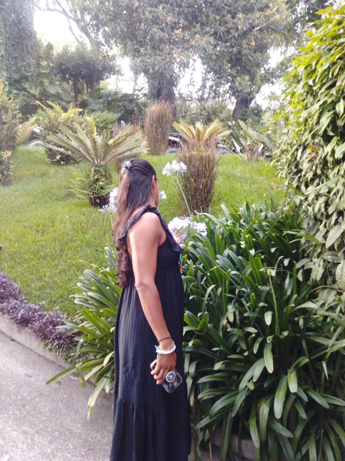 Guest walking through a lush Salvadoran garden at golden hour