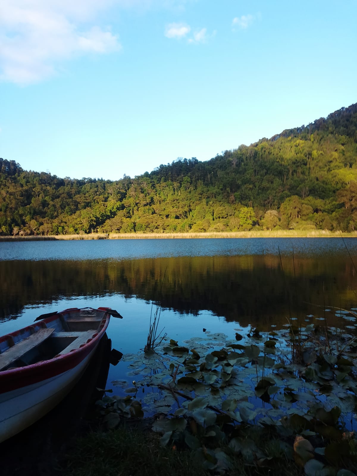 Alegría crater lagoon with a wooden boat on still water