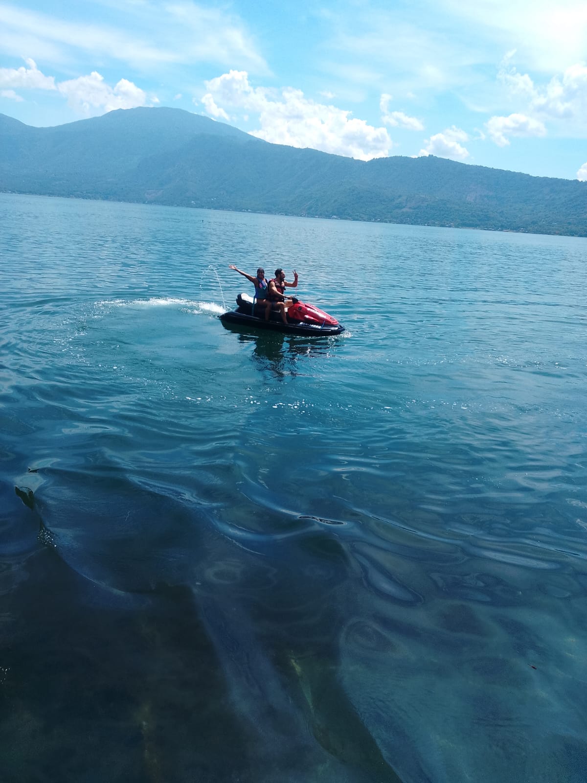 Travelers riding a jet ski on Lake Coatepeque