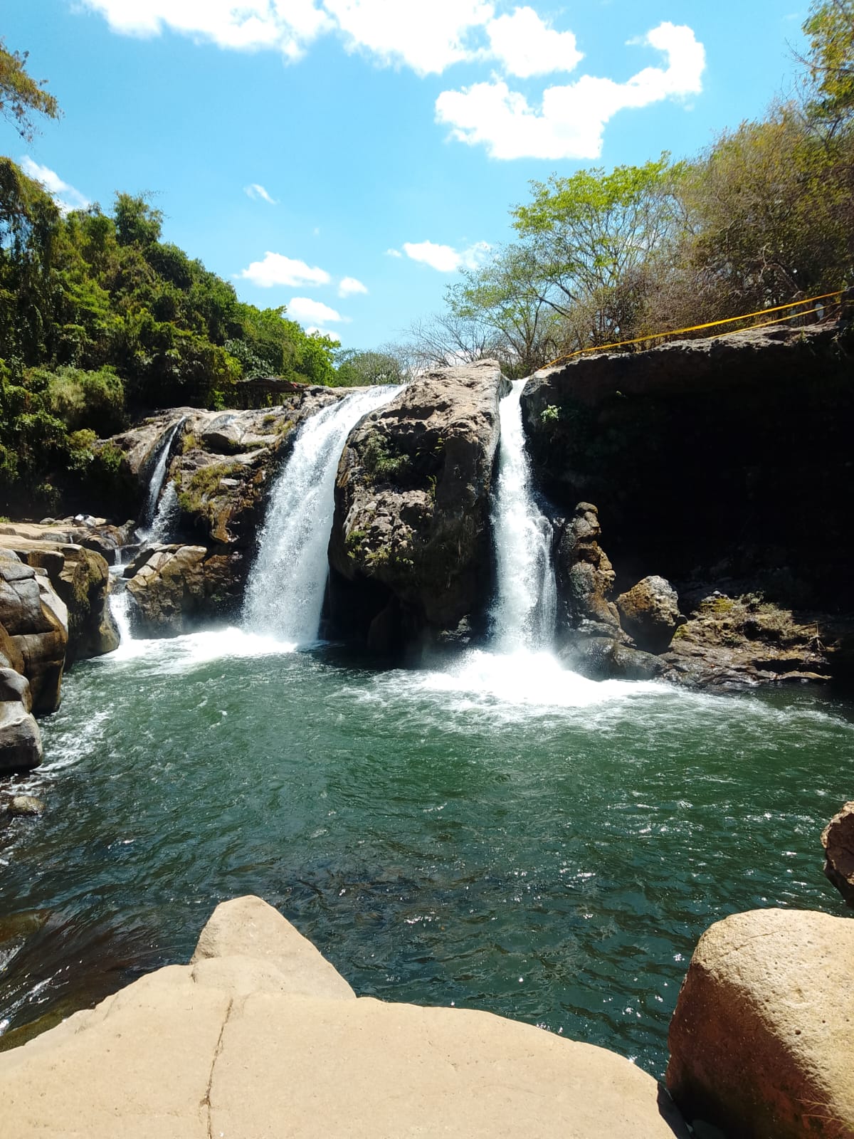 Twin waterfalls falling into an emerald pool
